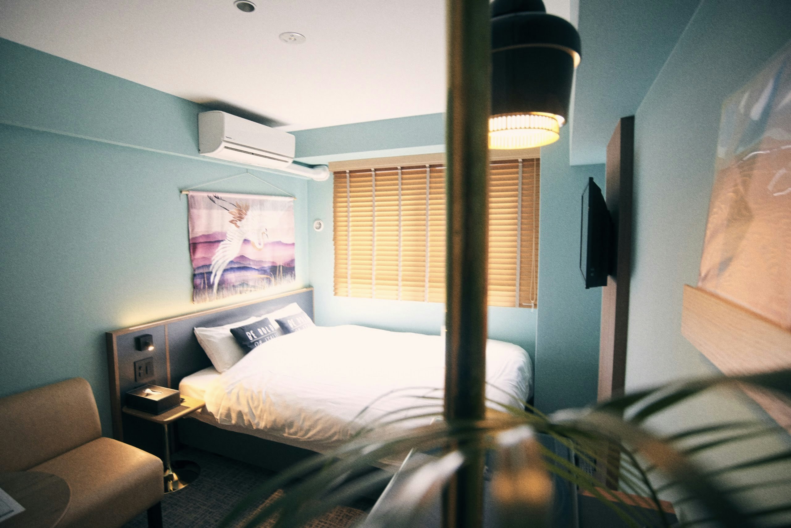 部屋はエメラルドグリーンの壁が映える小さなオアシス