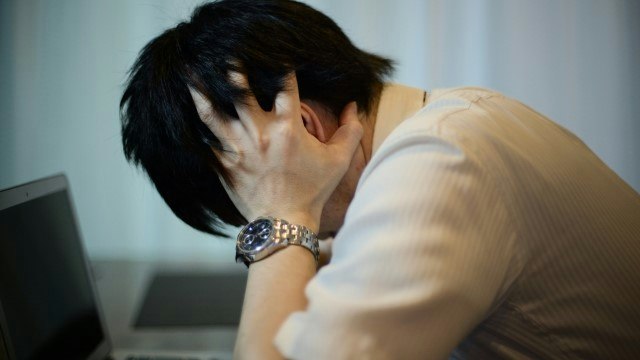 頭を抱えている男性