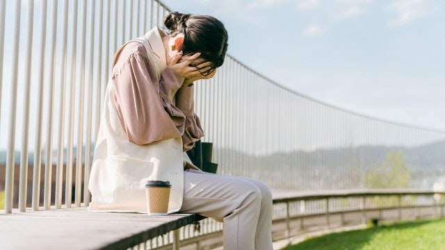 ベンチに座り泣いている女性の様子