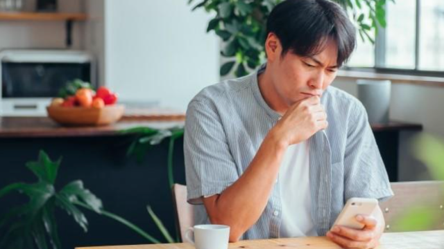 携帯を見て困っている男性