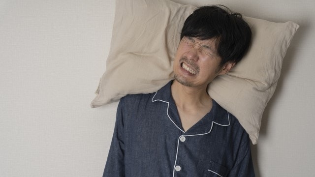 寝室で騒音に困っている男性