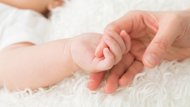 手をつなぐ赤ちゃんと女性