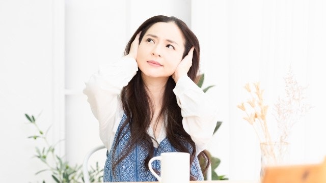 耳を塞いでる女性