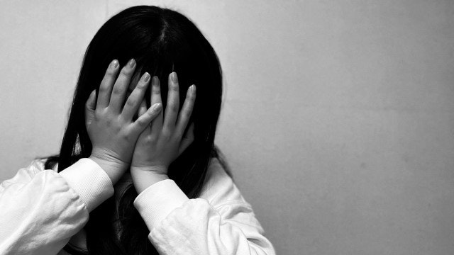 顔を抑える女性