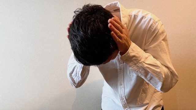 耳を塞ぐ男性