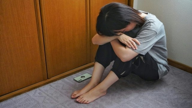 床にうずくまる女性