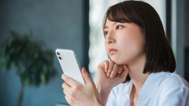 携帯を見つめている女性
