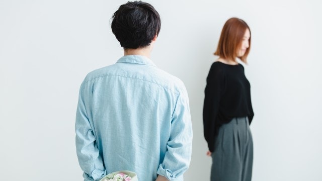 男性が女性を見つめて立っている後ろ姿