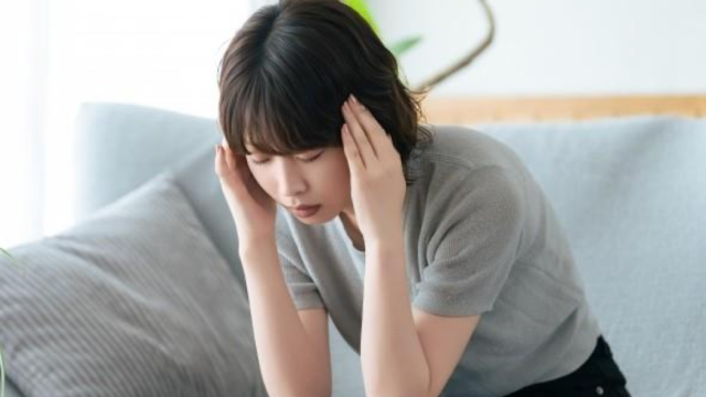 耳を塞いでいる女性