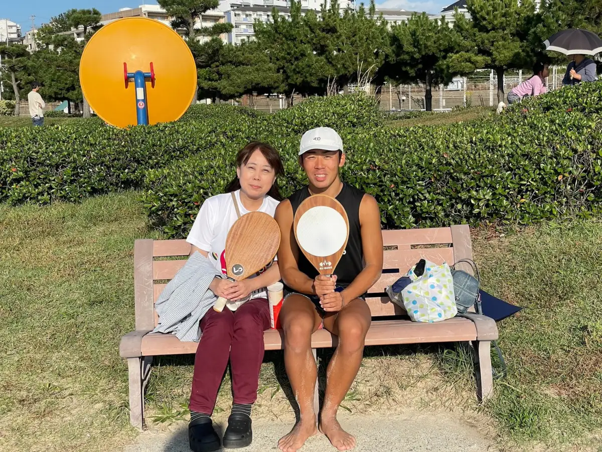 ラケットを持ってベンチに並んで座る中野克希選手と母親
