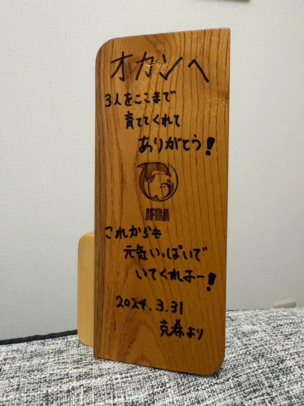 トロフィーの裏に手書きされた「オカンへ 3人をここまで育ててくれてありがとう!」のメッセージ