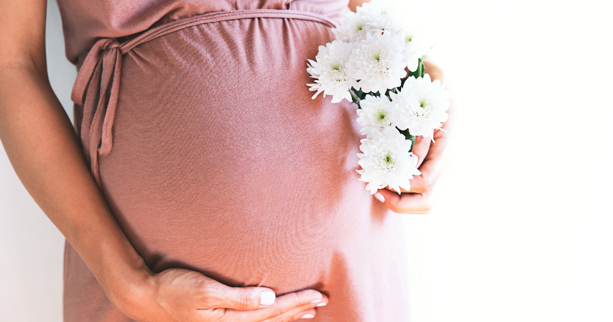 白い花束を持つ妊娠中の女性