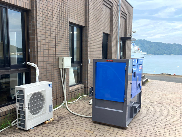 建物の壁面に取り付けたブレーカーと発電機