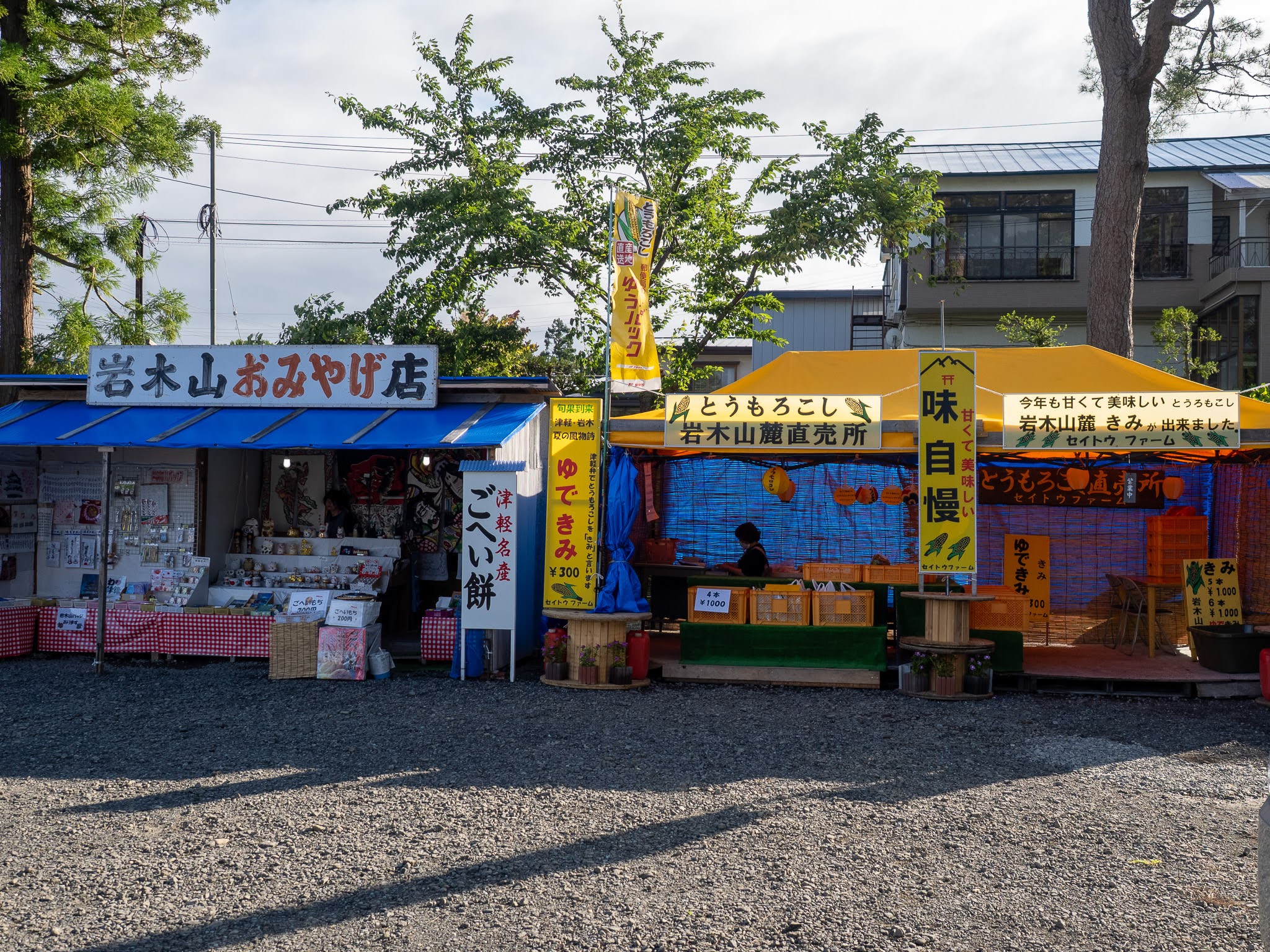 （一の鳥居前、駐車場の売店エリア。夏はとうもろこしの直売所も並びます。2026年8月撮影） 