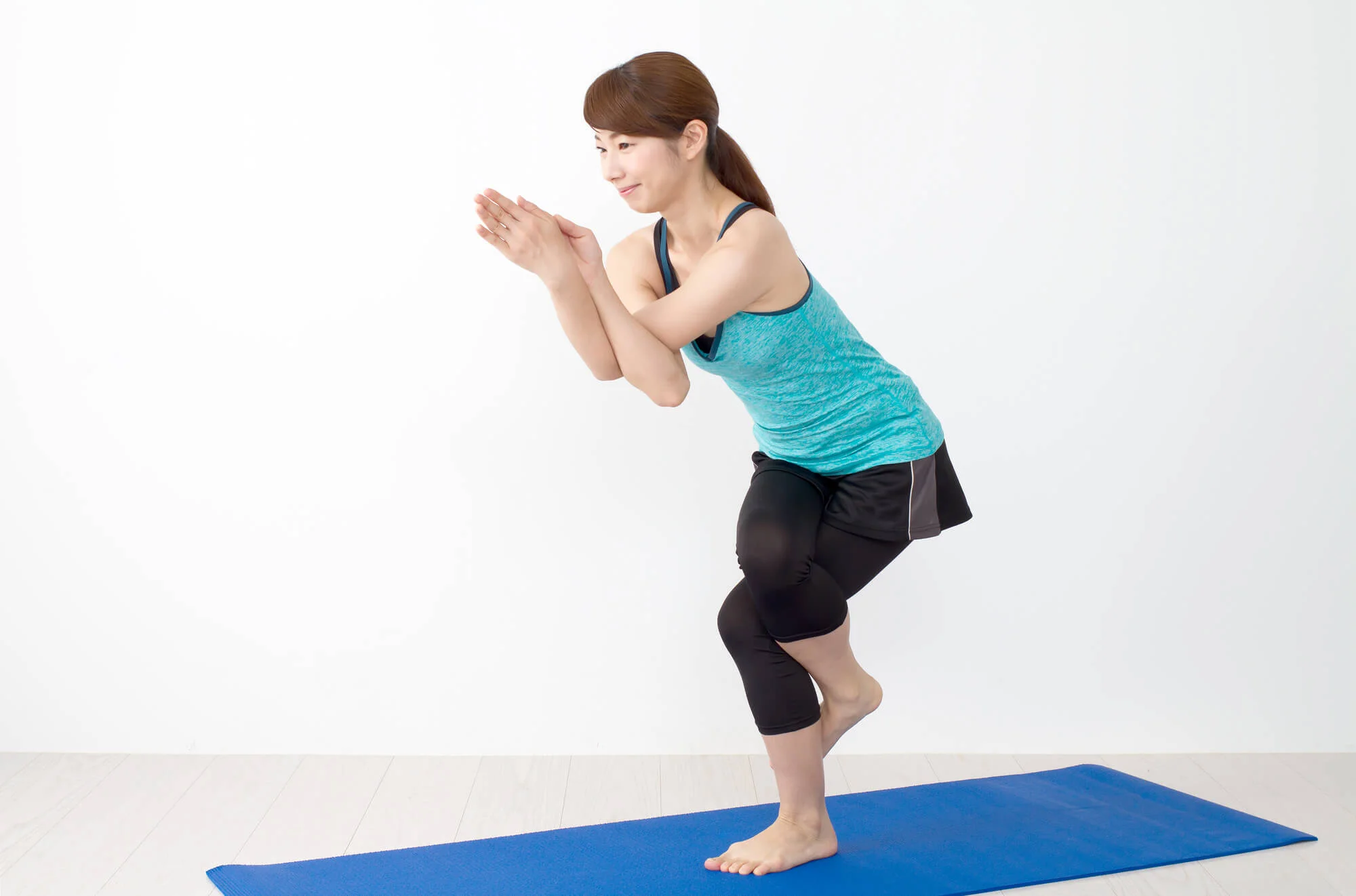 ヨガの鷲のポーズをする女性