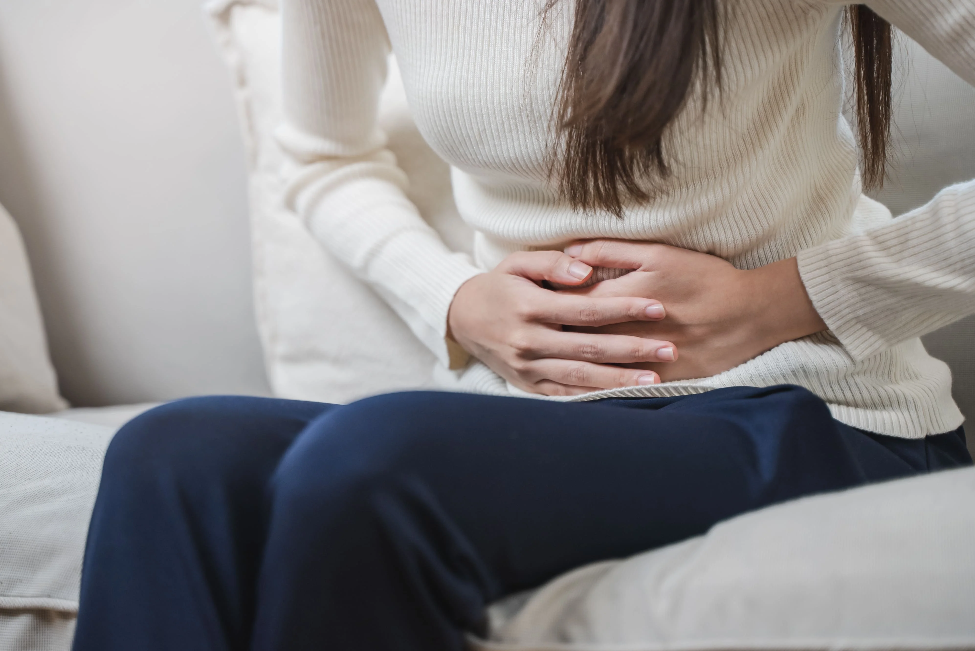 おなかを押さえる女性