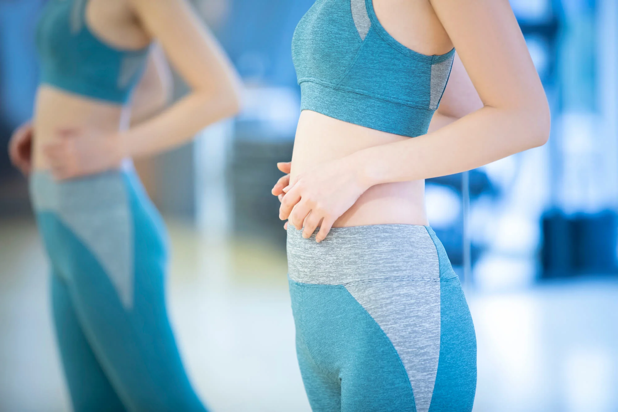 鏡で身体をチェックする1人の女性