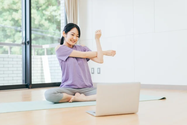 画面を見てストレッチする女性