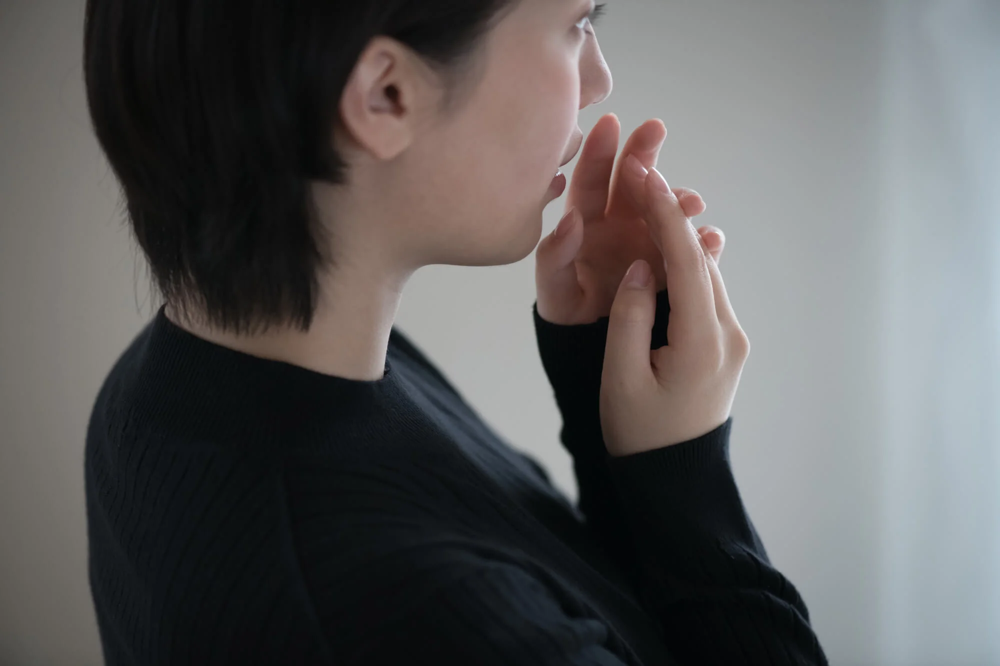 手に息を吹きかける女性