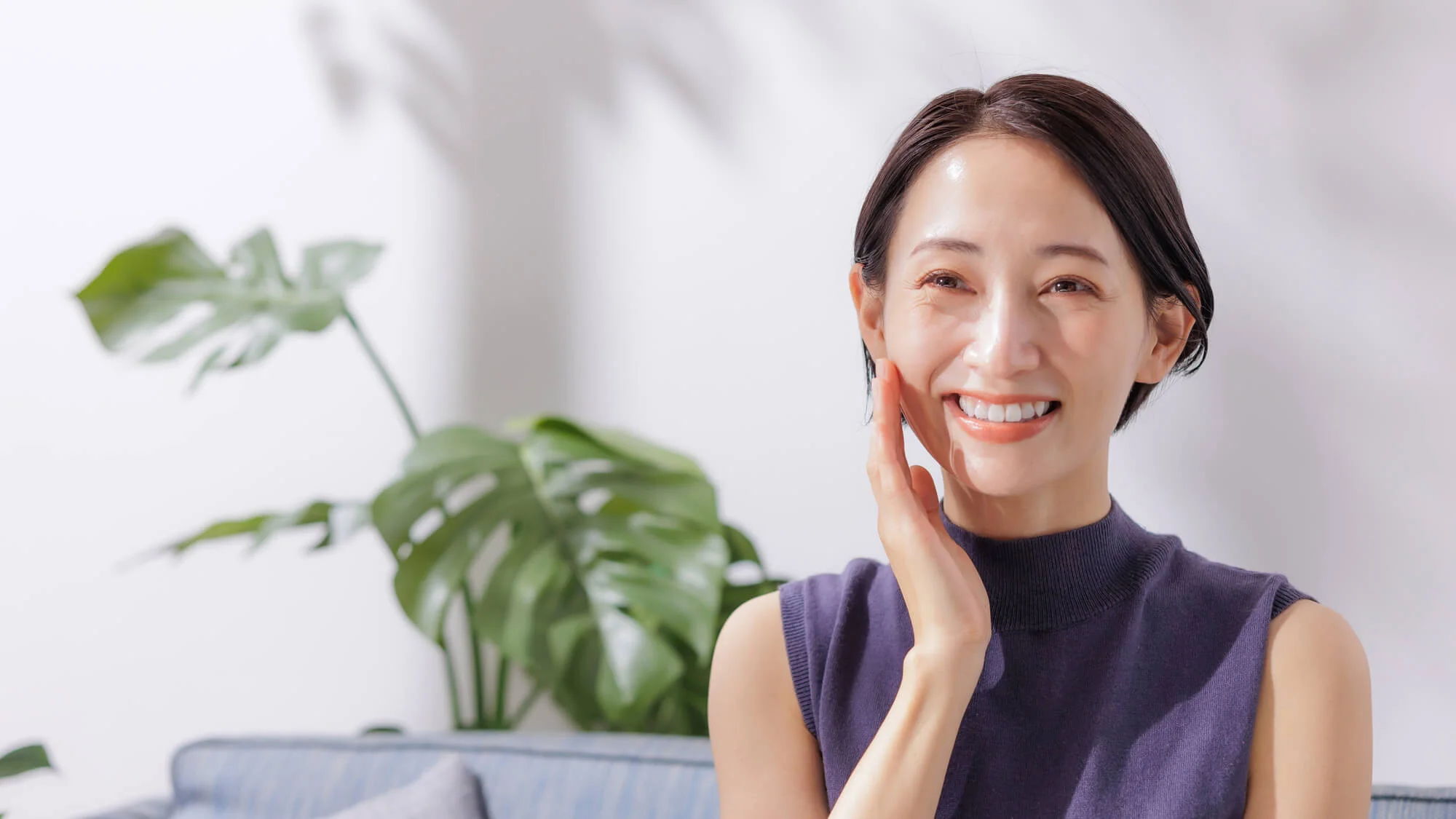 頬に手を当てほほ笑む女性