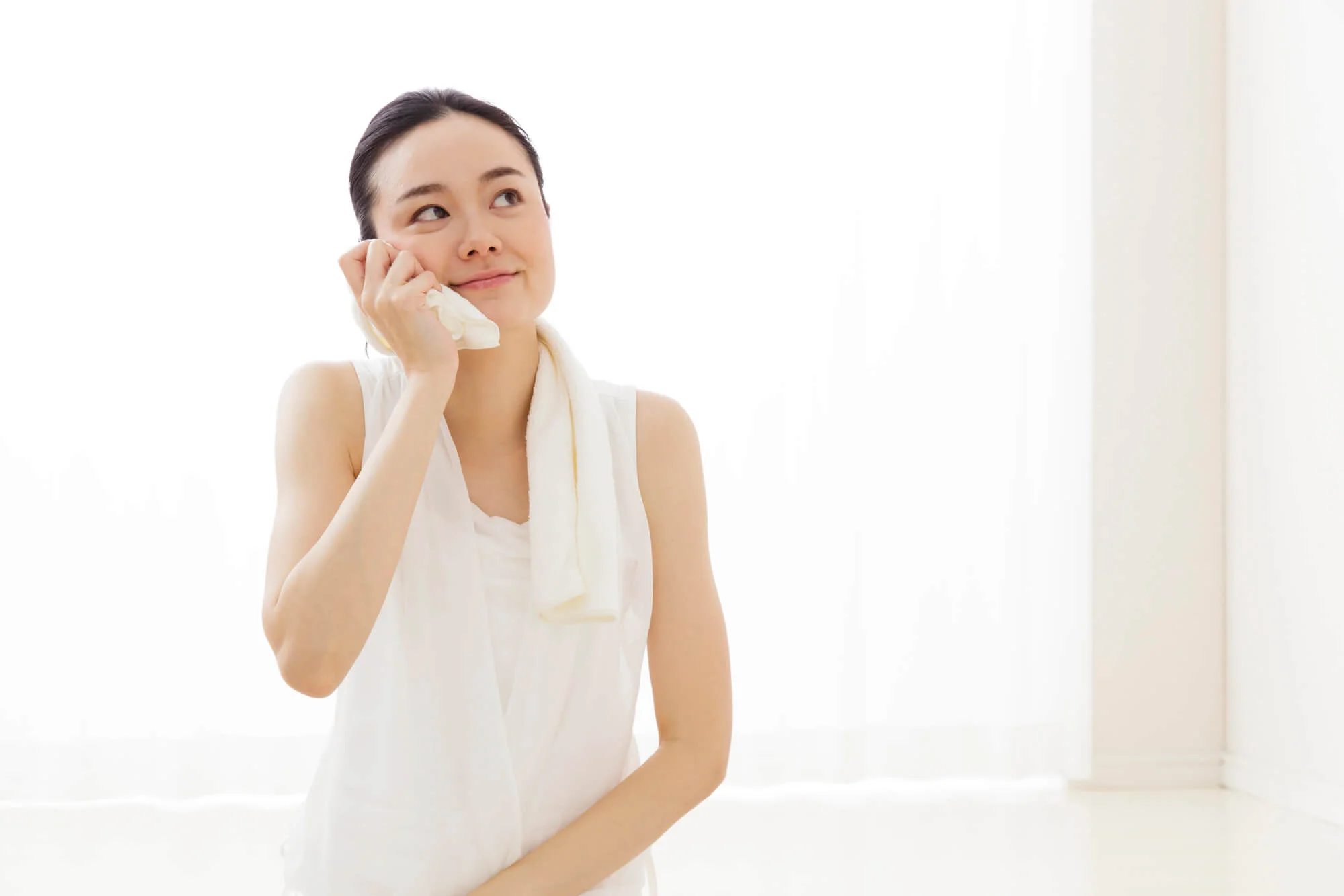タオルで顔を拭く女性
