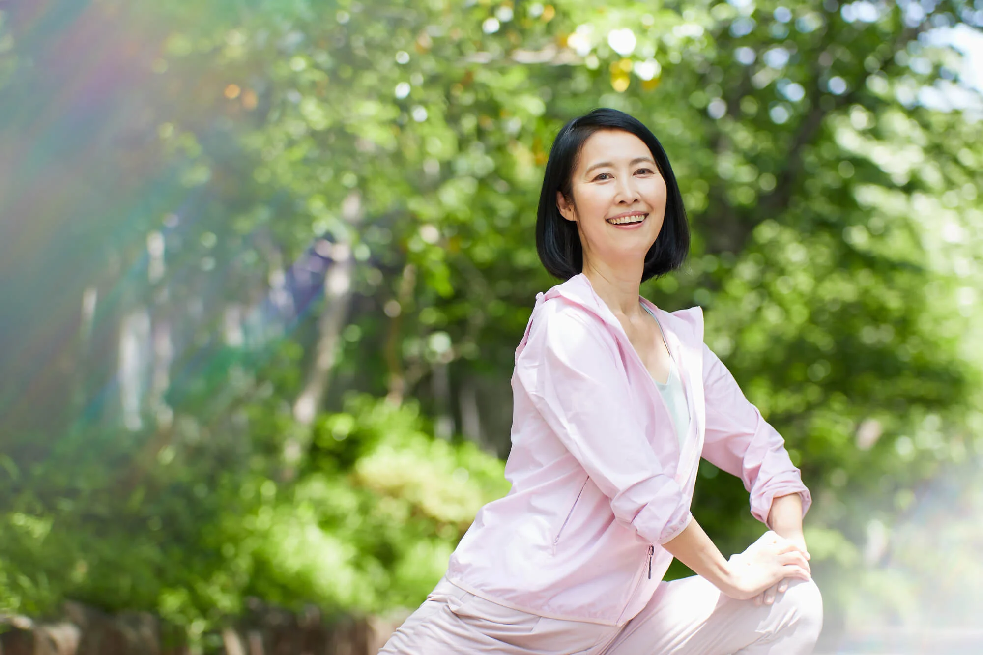 屋外でストレッチをする笑顔の女性