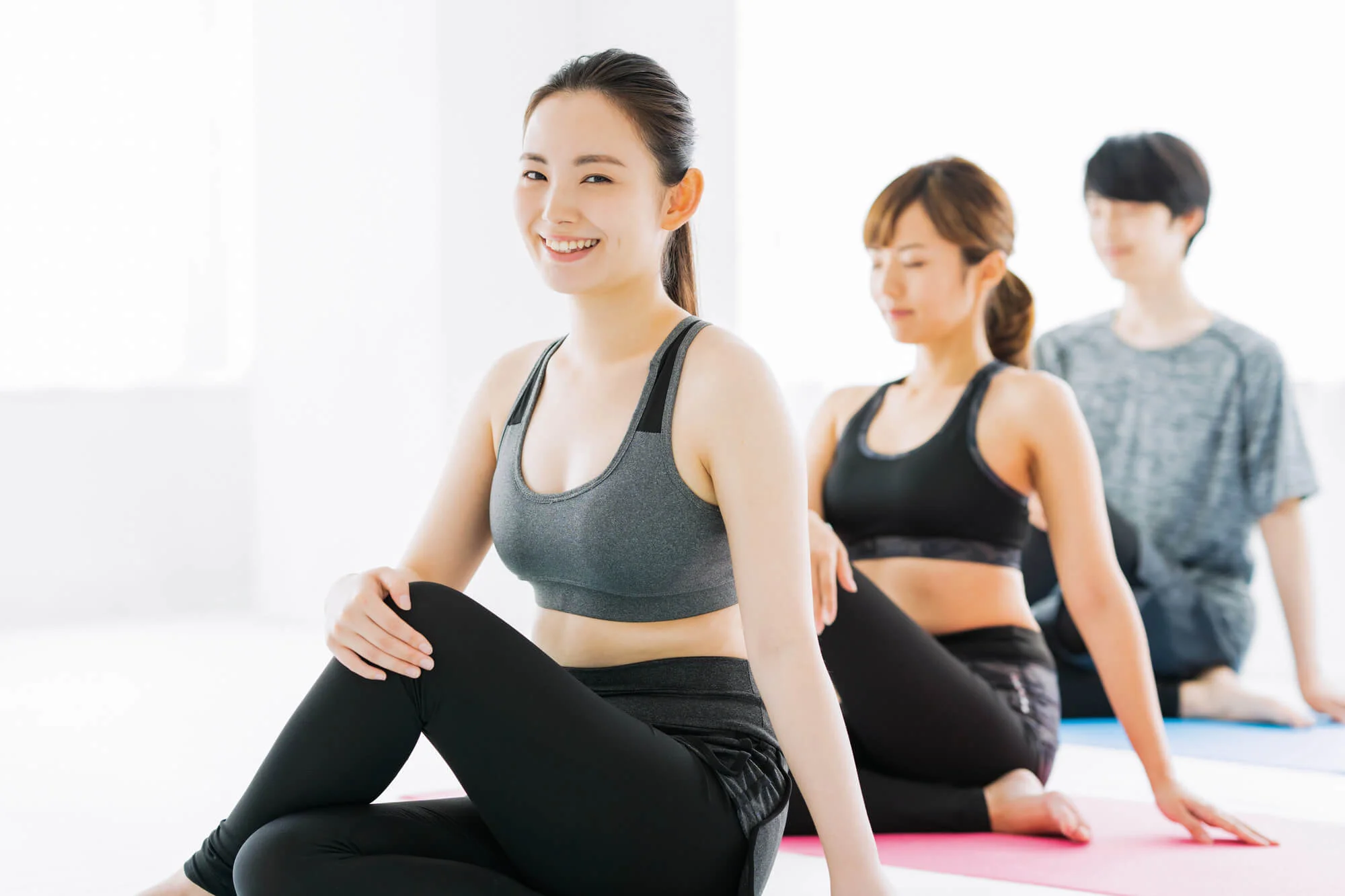 ピラティスのレッスンを受ける3人の男女