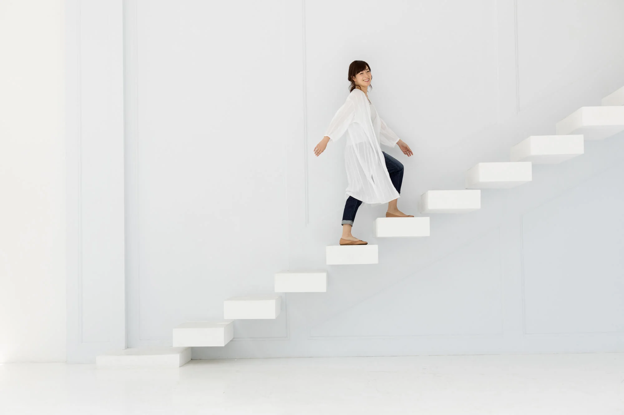 階段を笑顔で上る女性