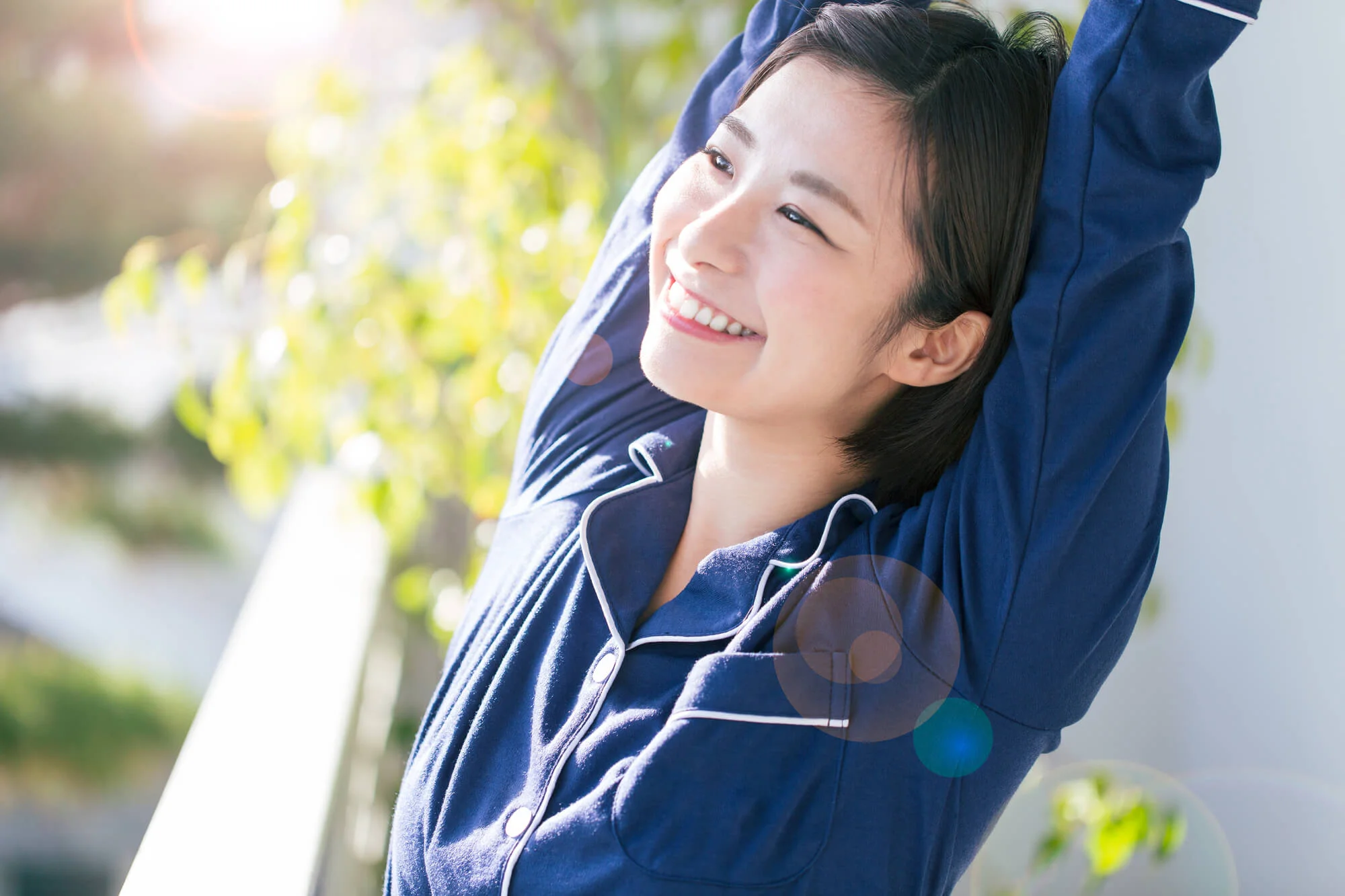 日差しを浴び、伸びをする女性