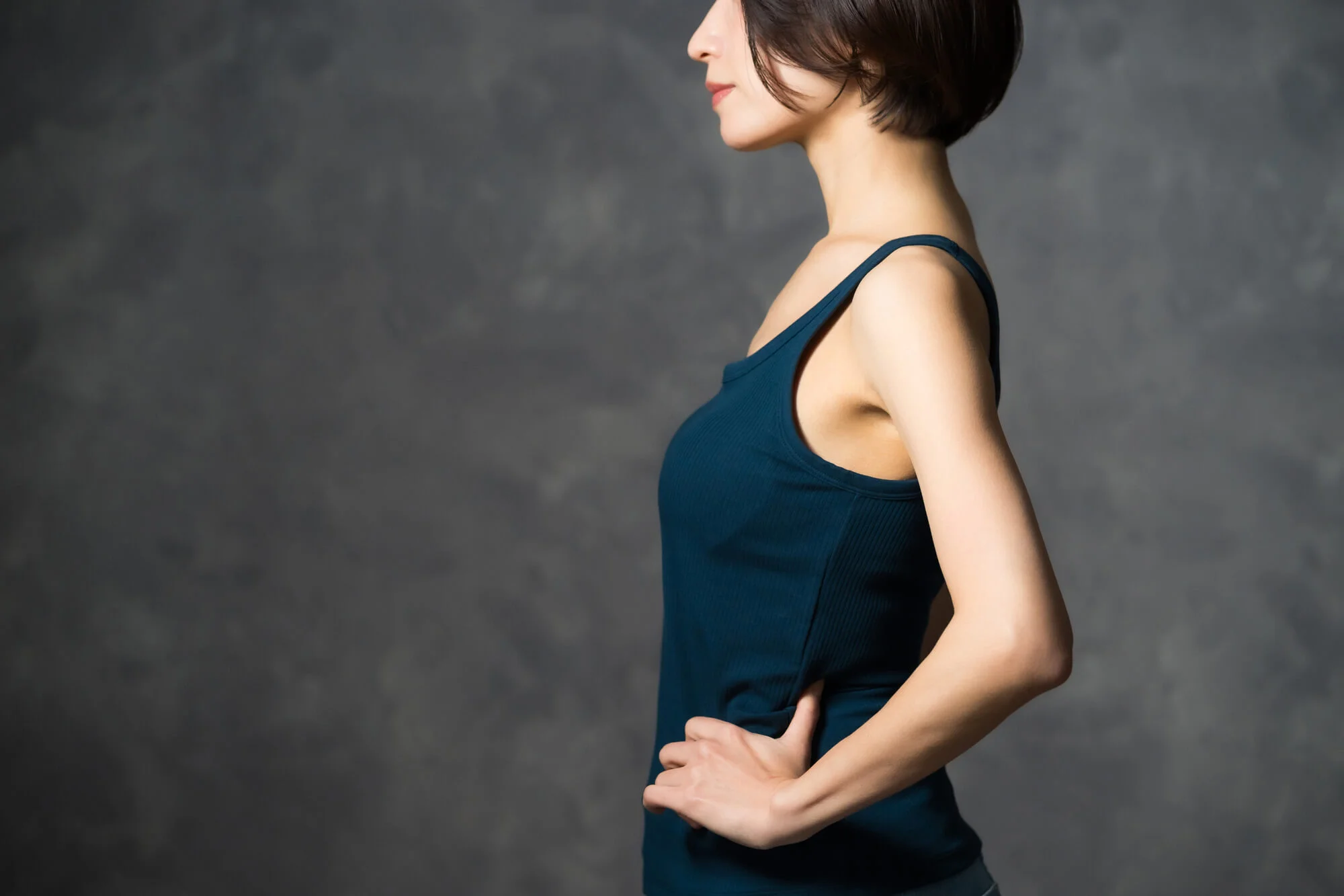 ウエストに手を当てる横姿の女性