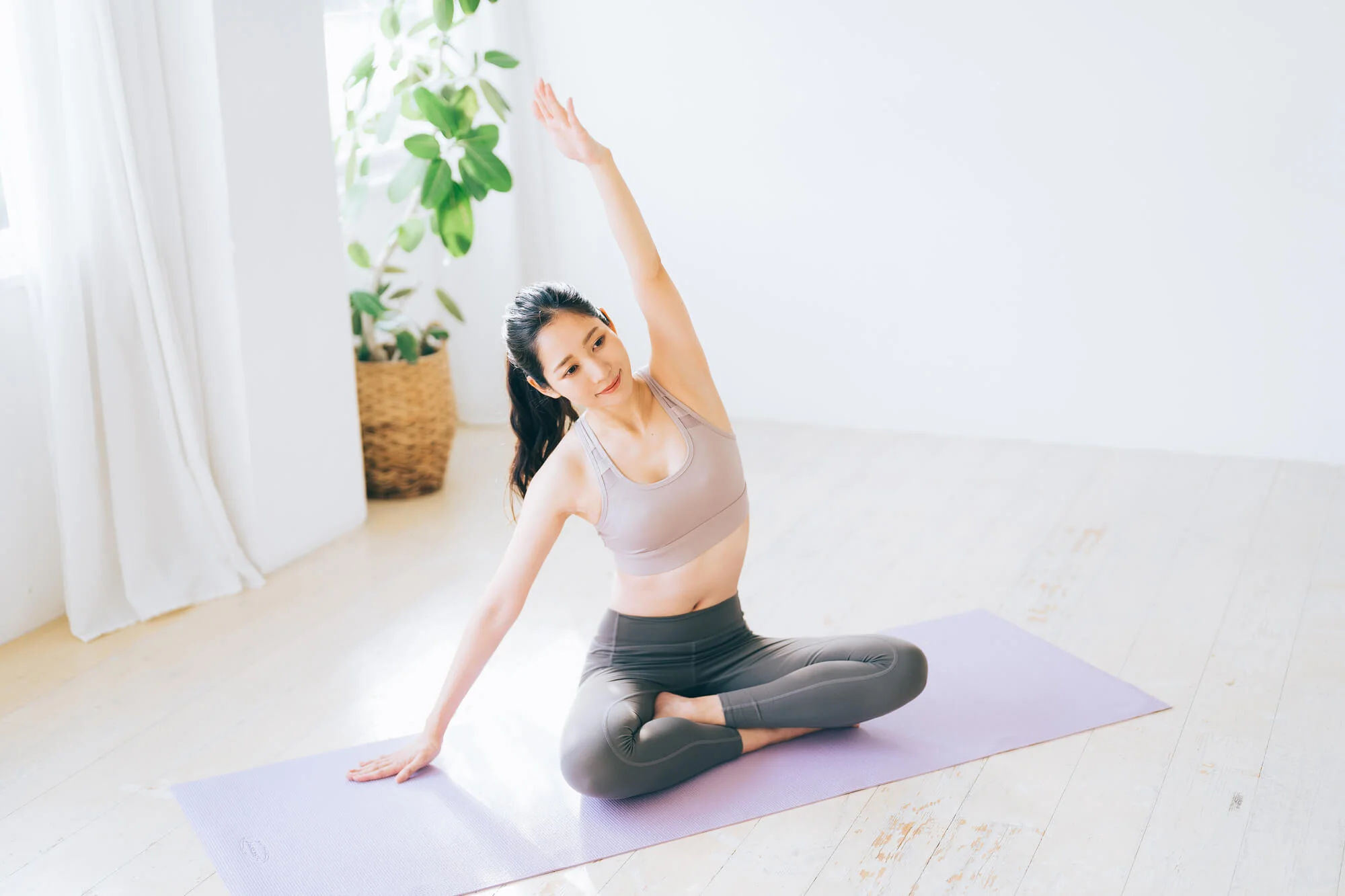 あぐらの姿勢でストレッチをする女性