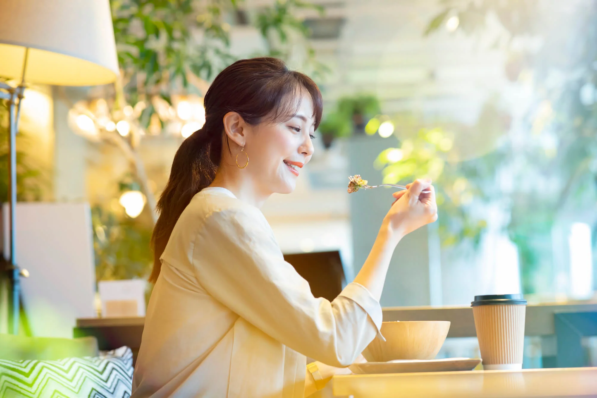 食事を口に運ぶ笑顔の女性