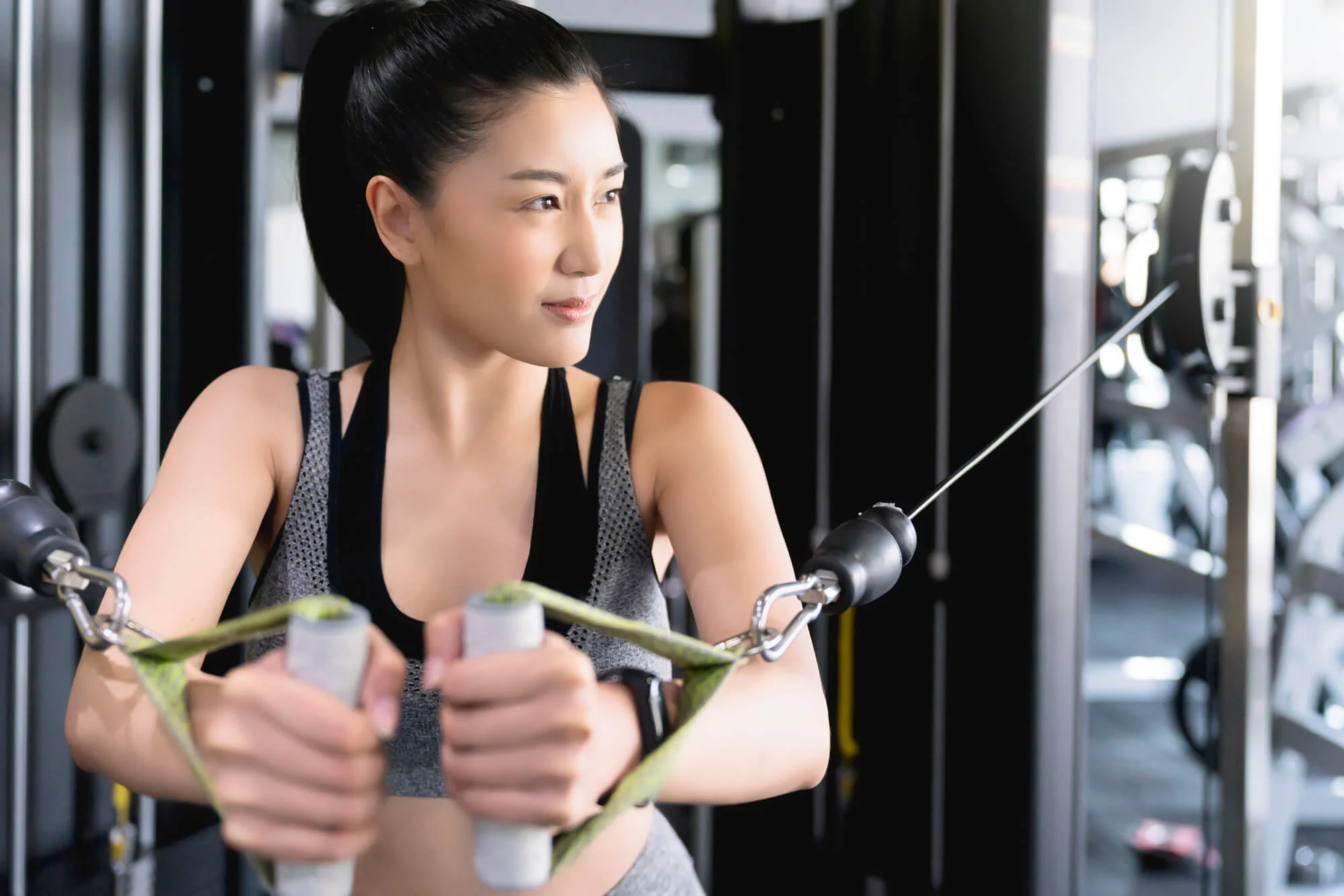 ジムのマシンで筋トレをする女性