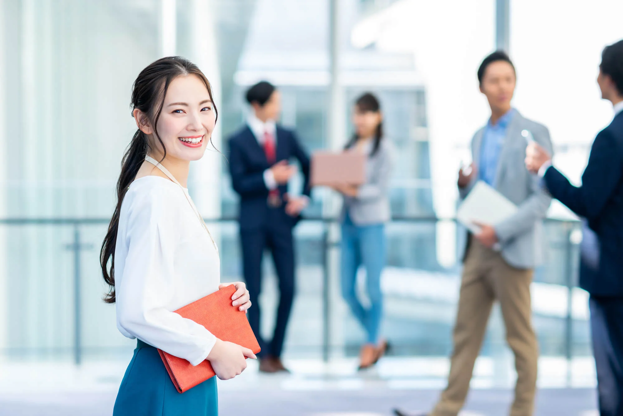 オフィスの廊下で笑顔を見せる女性