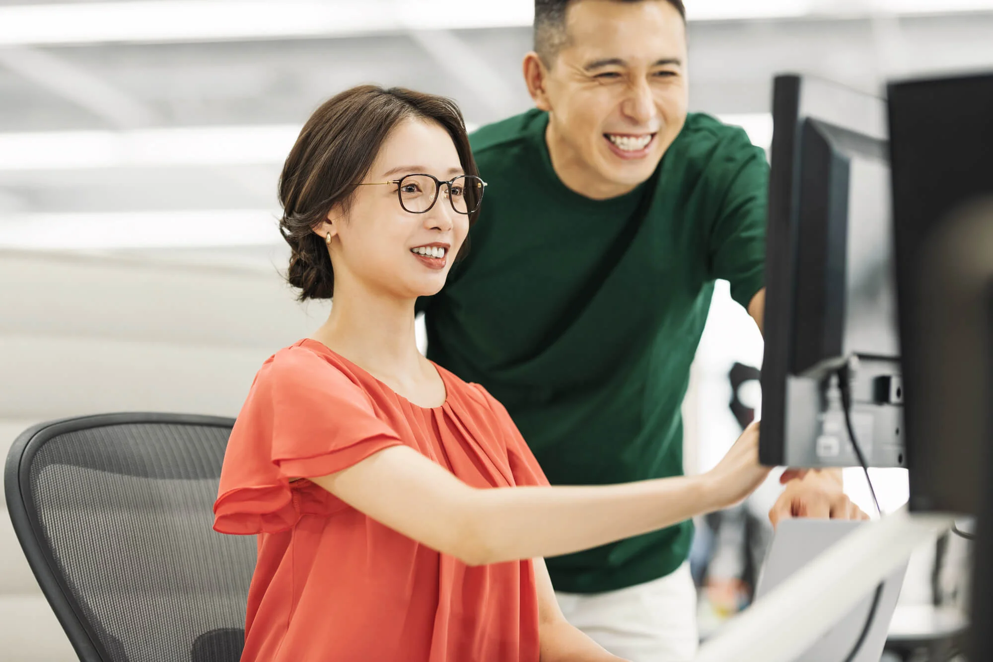 パソコンの前で指導を受ける女性