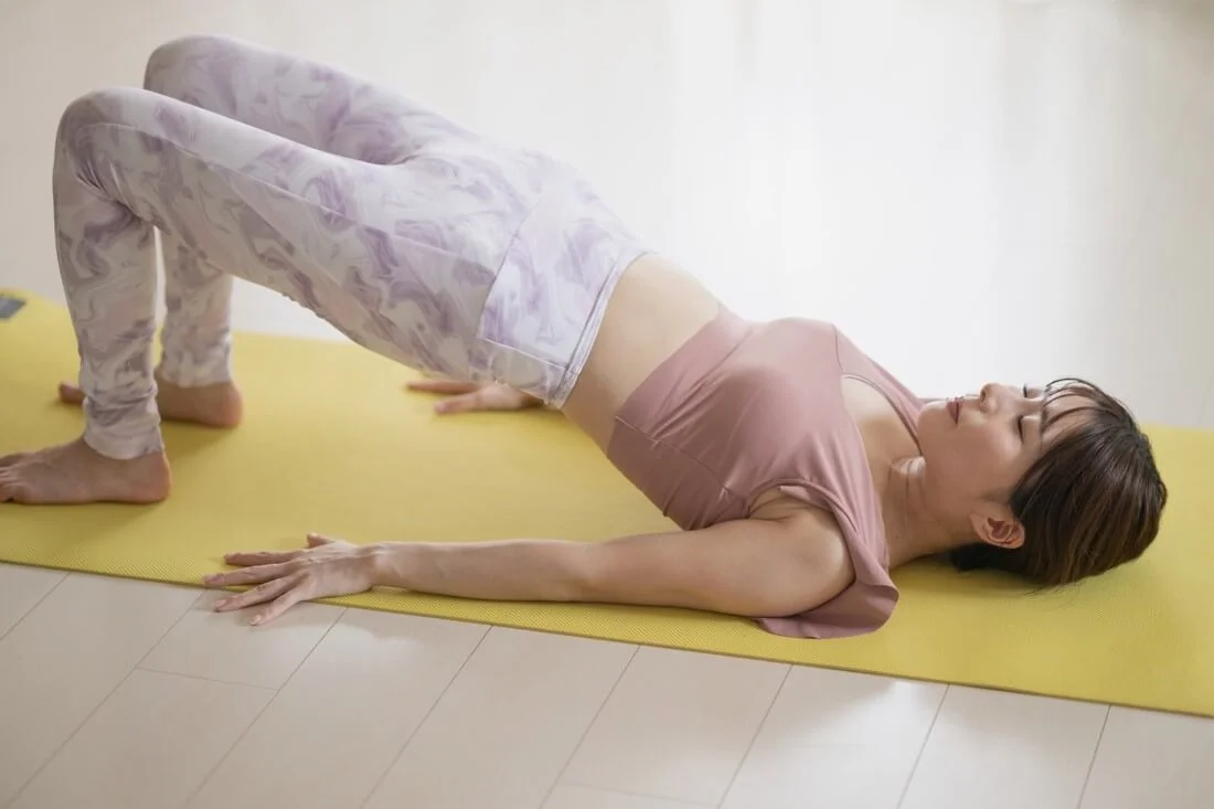 ピラティスのエクササイズを行う女性