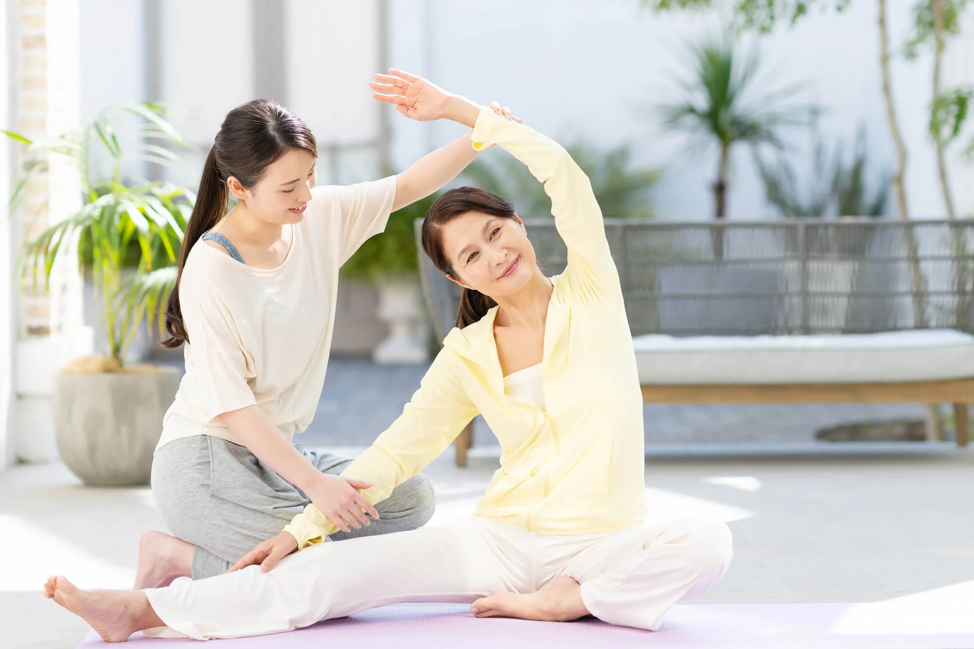 ヨガを教えるエデュケーターとレッスンを受ける女性