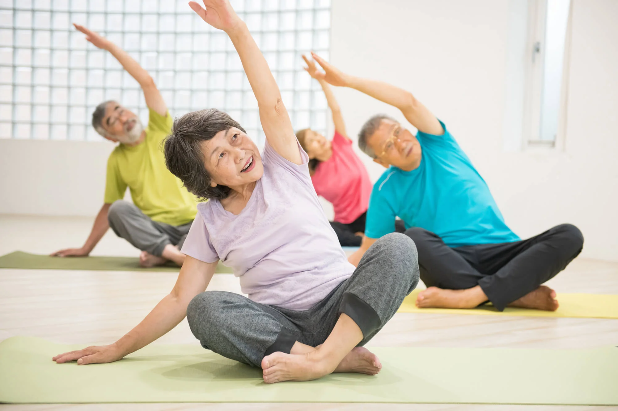 室内でストレッチをしているシニアのグループ
