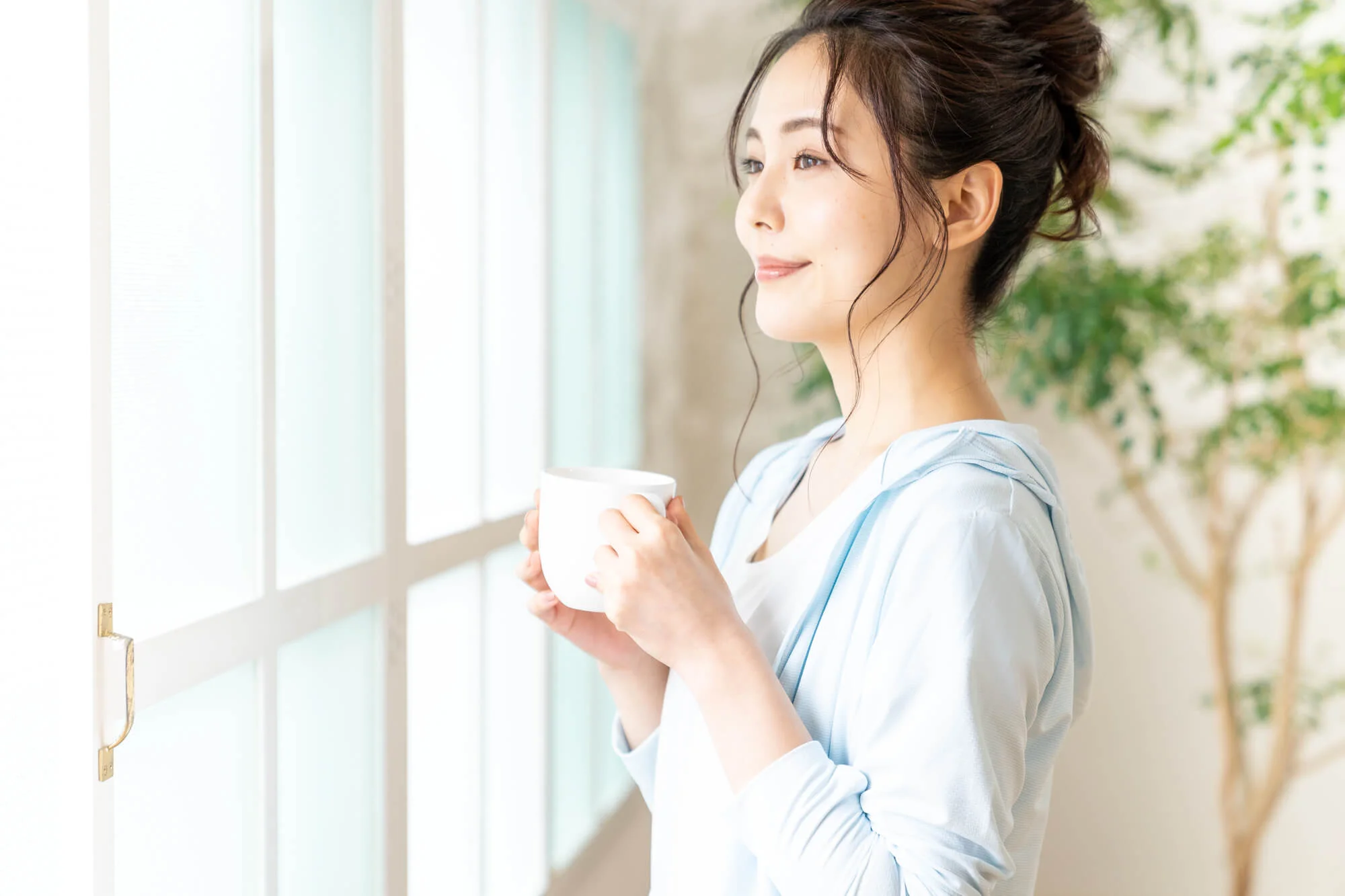 マグカップを手に温かい飲み物を飲む女性