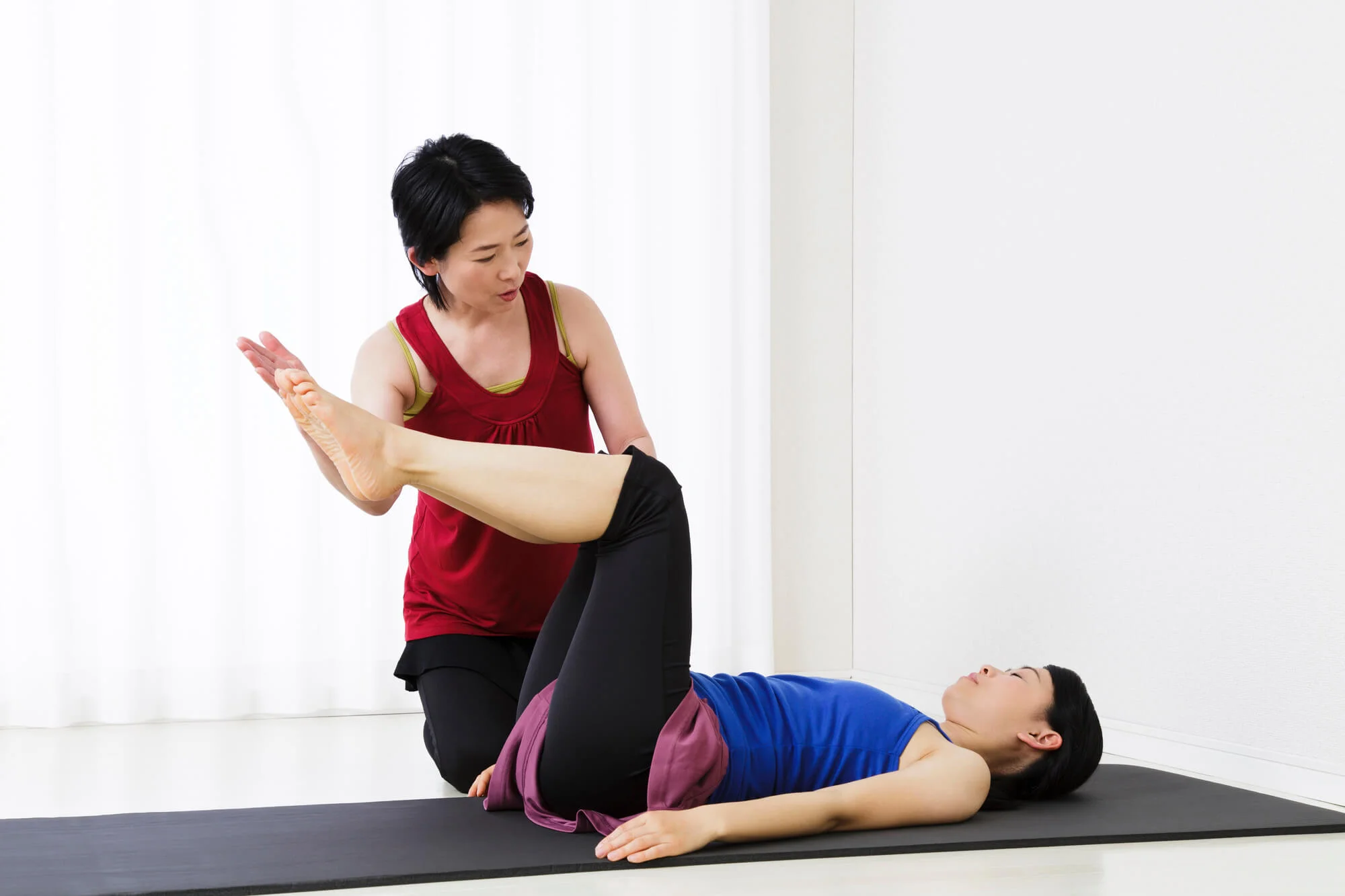 インストラクターの指導を受けながらエクササイズをする女性