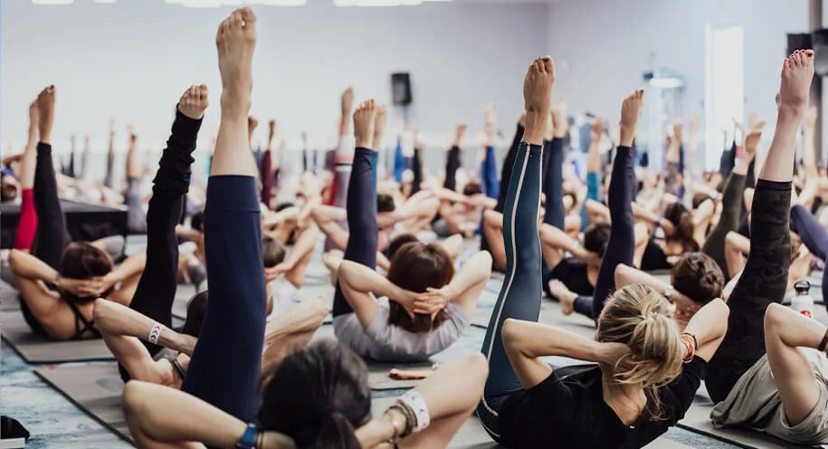 マットの上でピラティスを行う人たち