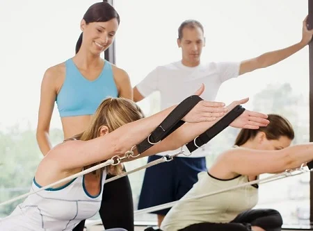 マシンピラティスの指導を受ける女性