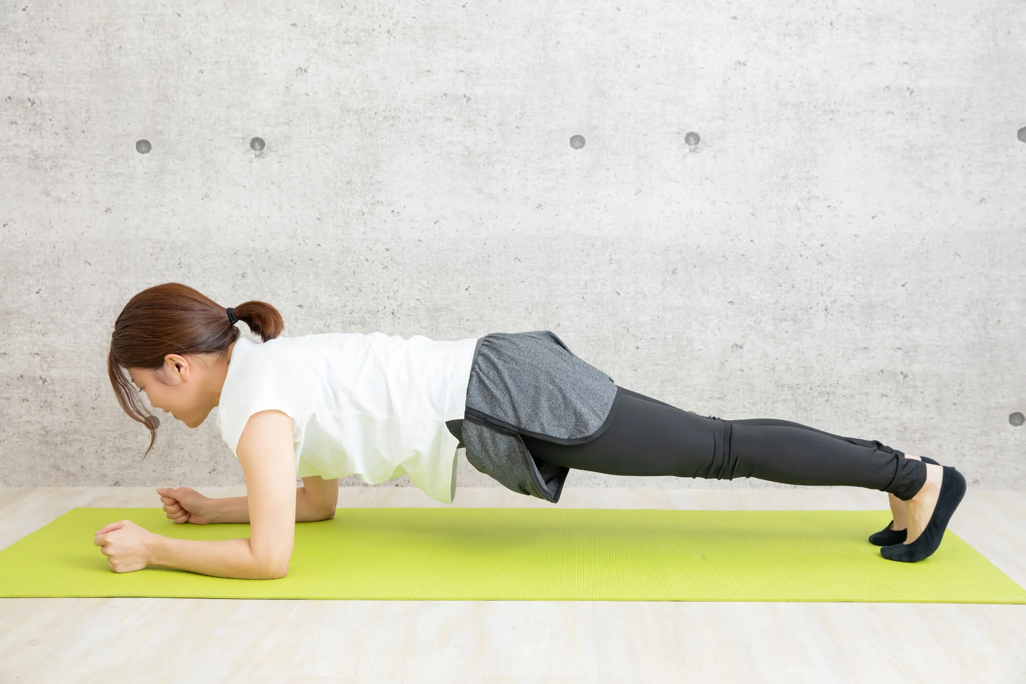 ヨガマットの上でプランクをする女性