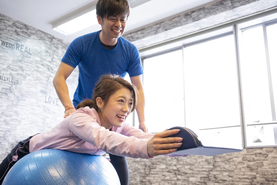 バランスボールに乗ってピラティスをする女性