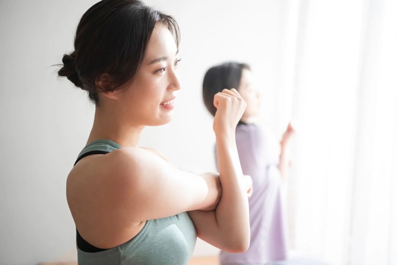 明るい日差しの中でピラティスに取り組む2人の女性