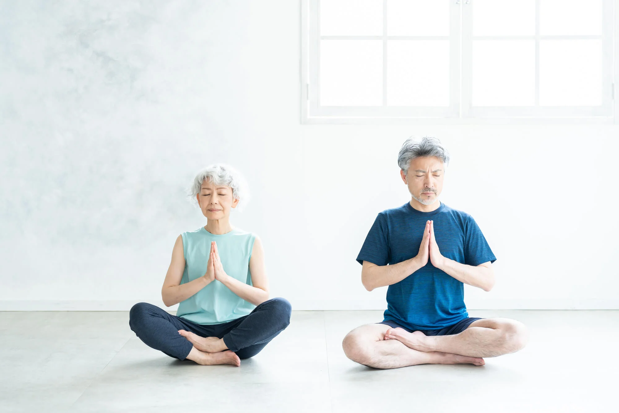 室内で瞑想をする夫婦