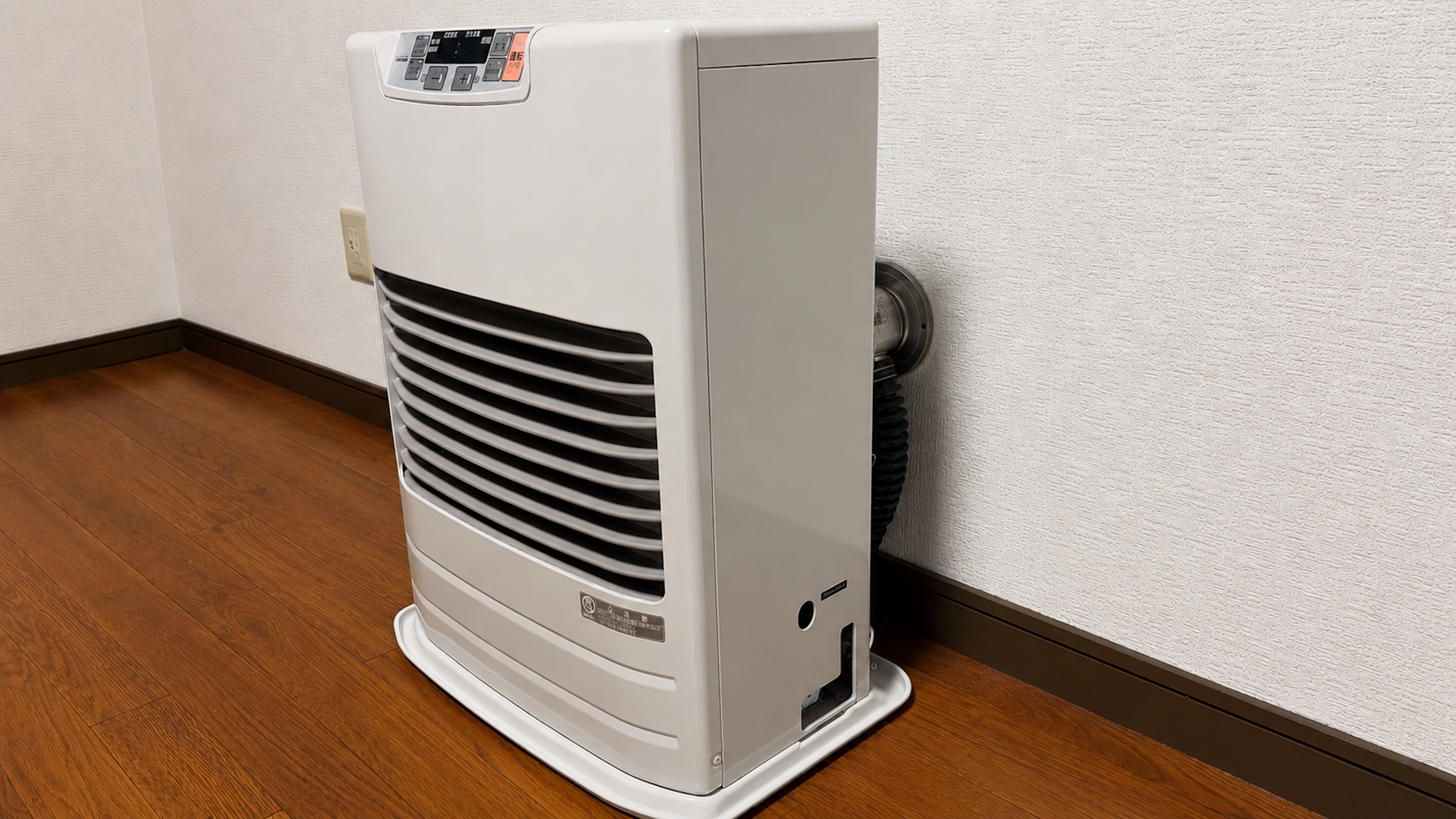 取り付けが完了したFF式ストーブ（温風式）。背面の給排気筒が壁の穴につながっている