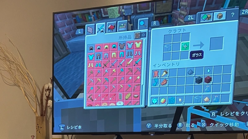 人気ゲーム「マインクラフト」のプレイ画面。テレビに日本語表示のゲームが映っており、所持品(インベントリ)とクラフトのメニューが開かれている。ダイヤモンドの剣や防具が揃ったインベントリから、プレイヤーがゲームをかなりやり込んでいることが推測される。
