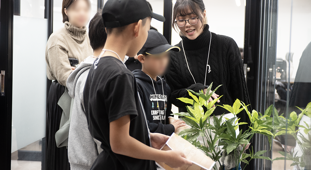 オフィスにある植木の中に、隠されていた暗号をコーチと生徒が見つけた