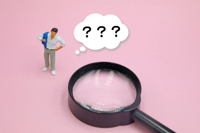 虫めがねと「？」の吹き出しの人